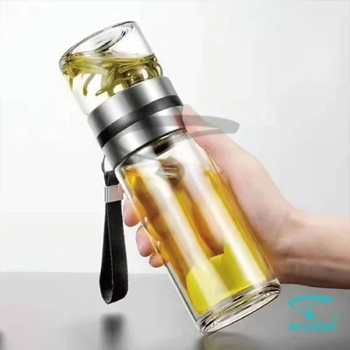 نحوه در دست گرفتن فلاسک دمنوش‌ساز پیرکس دوجداره M2019 و دم‌آوری چای سبز در مخزن شیشه‌ای بالایی.